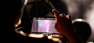 Übersicht über unsere Leistungen der Filmproduktion Karlsruhe mp-film bei den Dreharbeiten - das Bild zeigt eine Hand, die einen Kamerabildschirm bedient