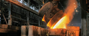 Einblicke in die Wirtschaft: Aus einem großen Stahlkessel wird flüssiges Eisenerz umgegossen.