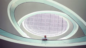 Ein futuristisches Treppenhaus in der SMA-Firmenzentrale. Ein Ingenieur schaut nach unten direkt in die Kamera. Imagefilm zum Thema Technologie der Filmproduktion Karlsruhe mp-film für SMA Solar Technology