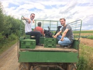 Zwei Teammitglieder sind auf den Feldern unterwegs und das auf der Ladefläche eines alten Traktors die mp-film Filmproduktion Karlsruhe bei Dreharbeiten für Metro