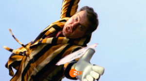 Ein Hausbesitzer im Bademantel hechtet nach einem runden Brief der ihm zwischen den Fingern durchrutscht. Screenshot aus einer Serie Werbespots der Filmproduktion Karlsruhe mp-film für das ZDF.