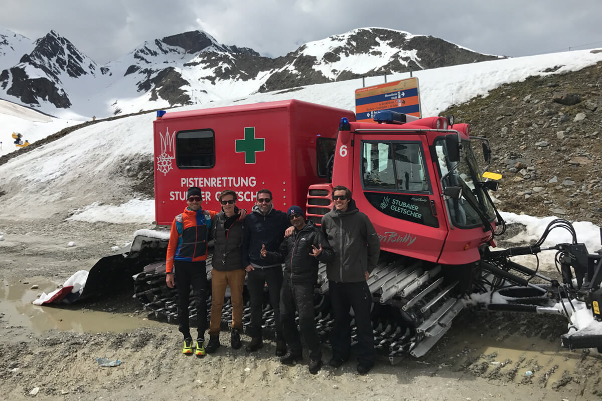 5 Personen des Filmteam der Filmproduktion Karlsruhe mp-film vor einer roten Pistenraupe im Schnee des Stubaier Gletschers in Tirol