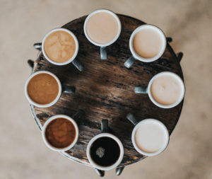 Tassen gefüllt mit Kaffee auf einem Tablett aus Holz
